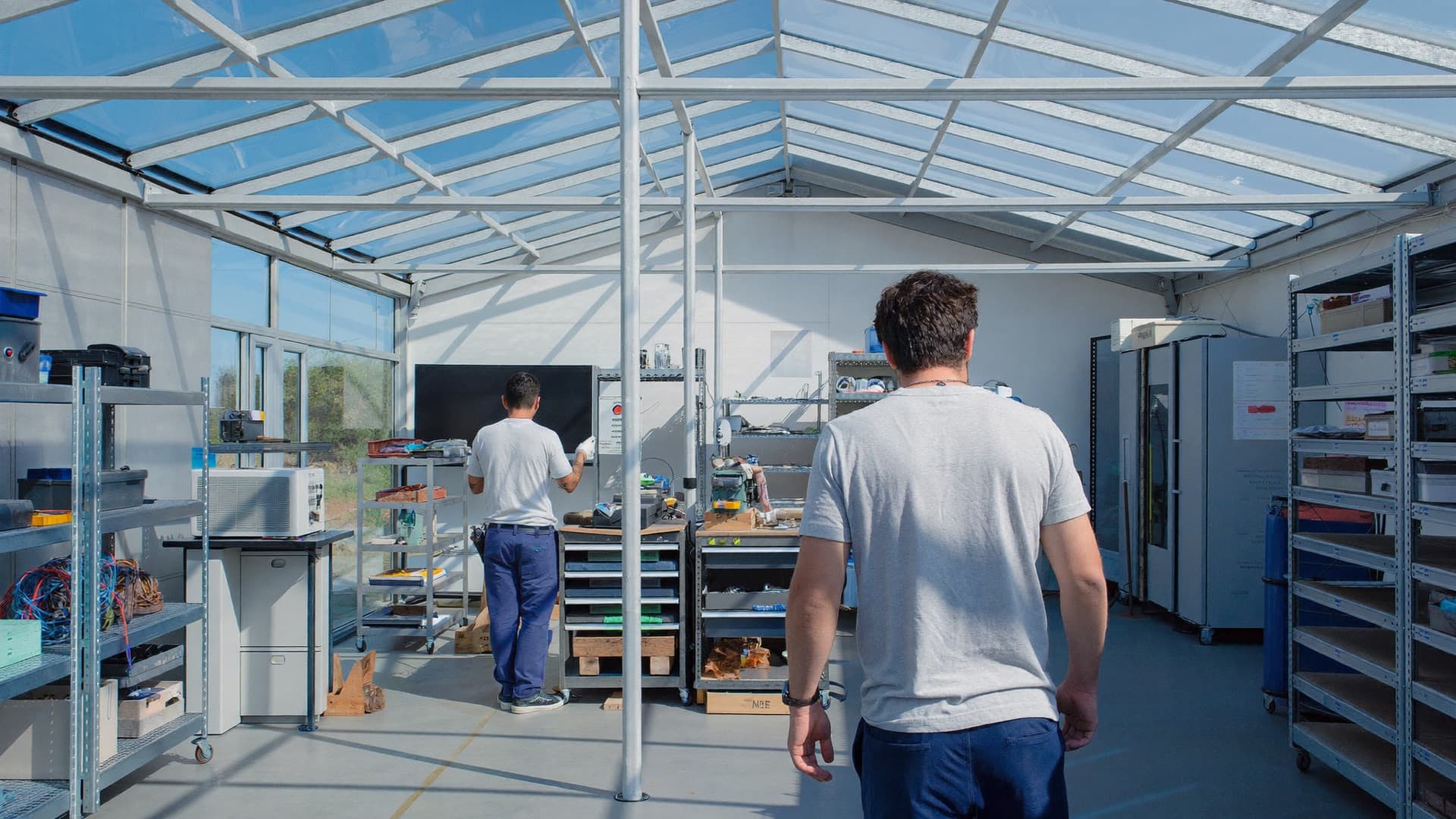 Atelier lumineux d'une petite entreprise, deux artisans au travail sous une verrière